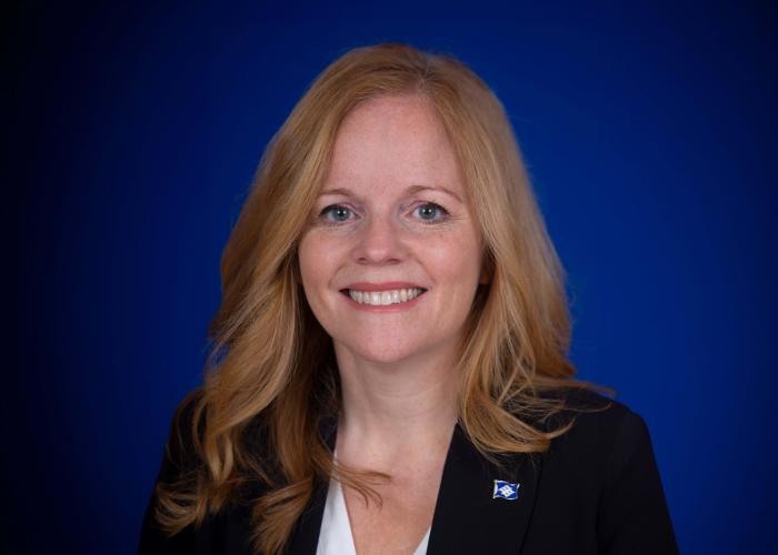 A photo of a woman in front of a blue background