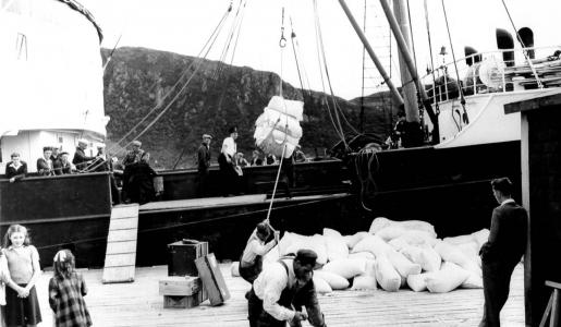 Image: dock workers hoisting goods onto the SS Burgeo